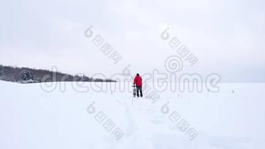 一个骑着山地车的人。 比克正在雪地里推自行车。 多云的冬日，风和雪花轻柔